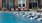 a pool in front of a brick building with a fountain in the front