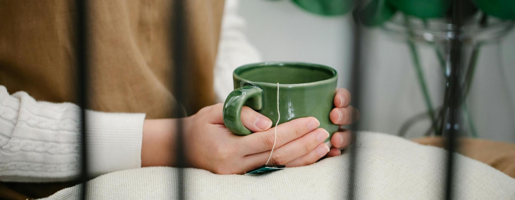 a person holding a green cup